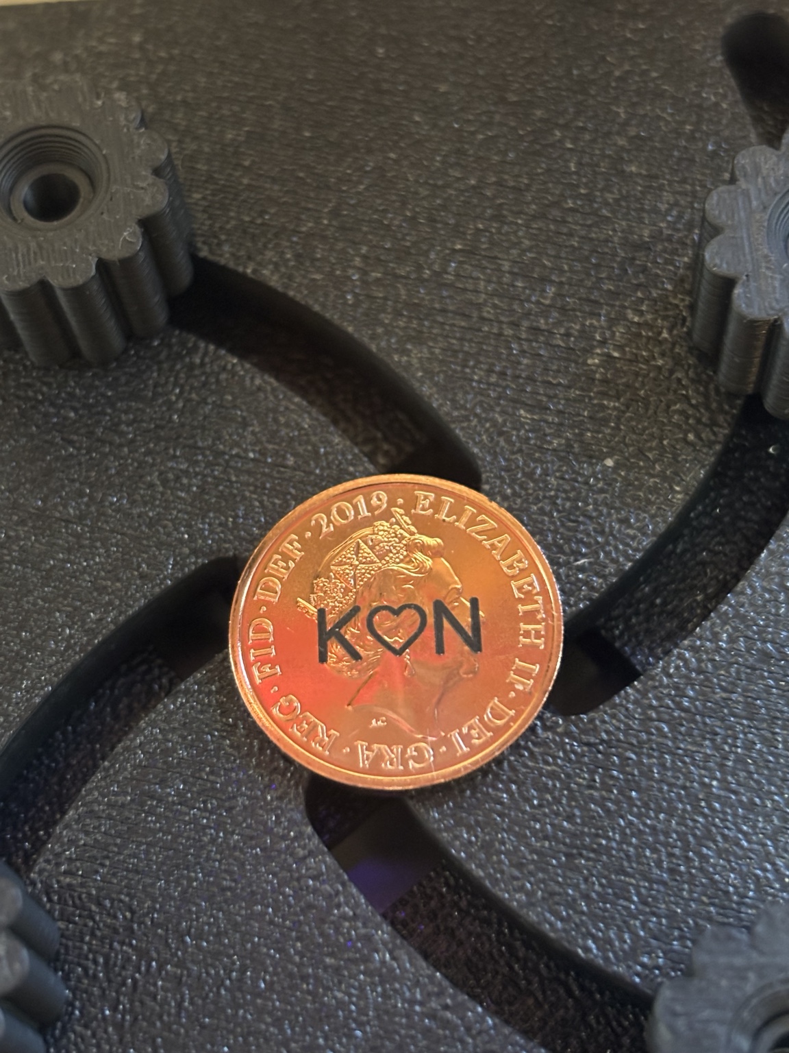 Close-up of a penny personalised with the initials K and N and a heart